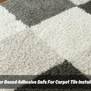 Close-up of a gray and white checkered carpet tile with a small amount of white carpet tile adhesive spread in the corner
