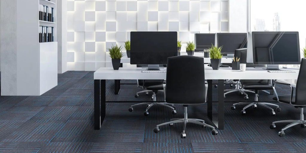 Close-up of square carpet tiles in a modern office workspace.