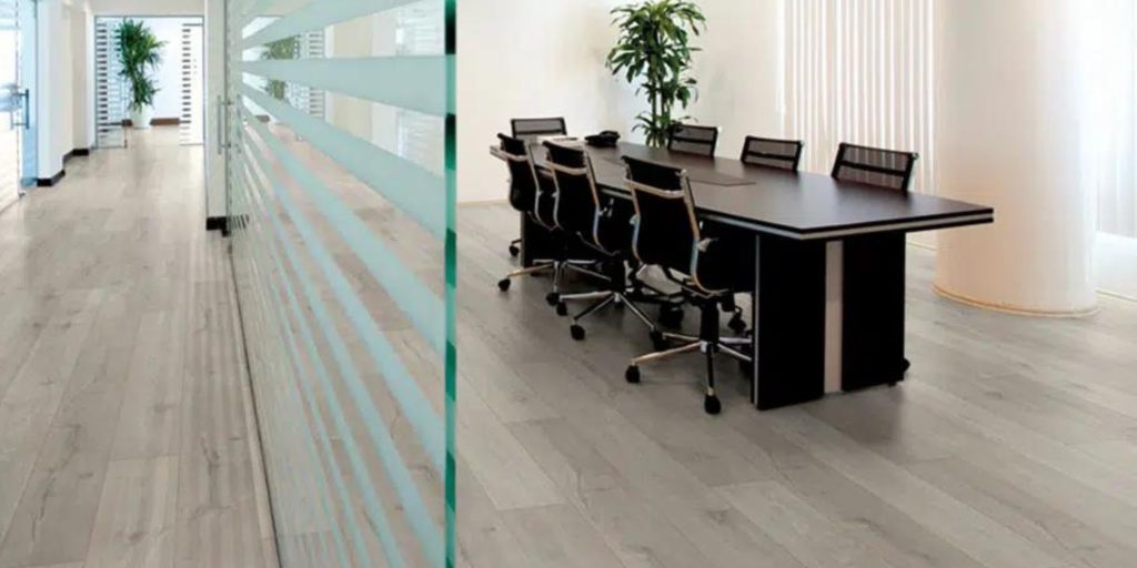 Conference room with a long table and chairs on vinyl flooring. Vinyl flooring for offices is a popular choice for durability and ease of cleaning.