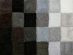 Various carpet tile samples showing different colours and thicknesses to determine the best thickness of carpet tile.