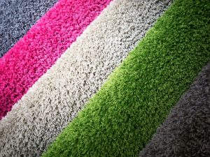 Colourful carpet tiles displayed in layers, highlighting the thickness of carpet tile options for interior spaces.