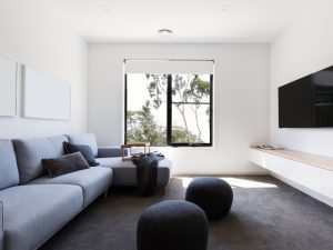 Modern living room with grey carpet improving indoor air quality by reducing airborne dust and allergens.